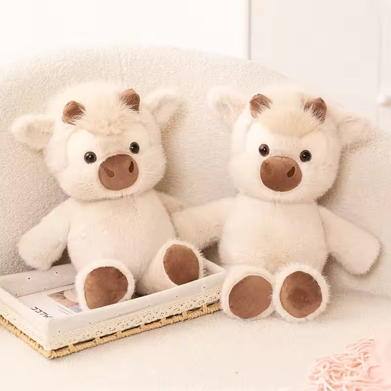 Two white teddy bears with brown paws and noses on a white surface.